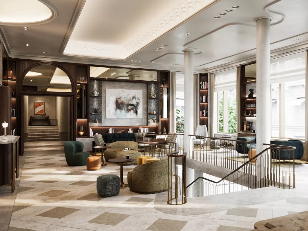 A hotel lounge with velvet armchairs, marble floors, a sweeping staircase and tall windows