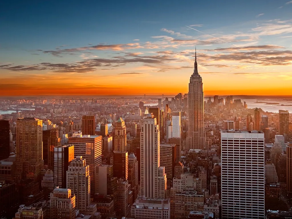 The Manhattan skyline at sunset, with the Empire State Building rising above the city